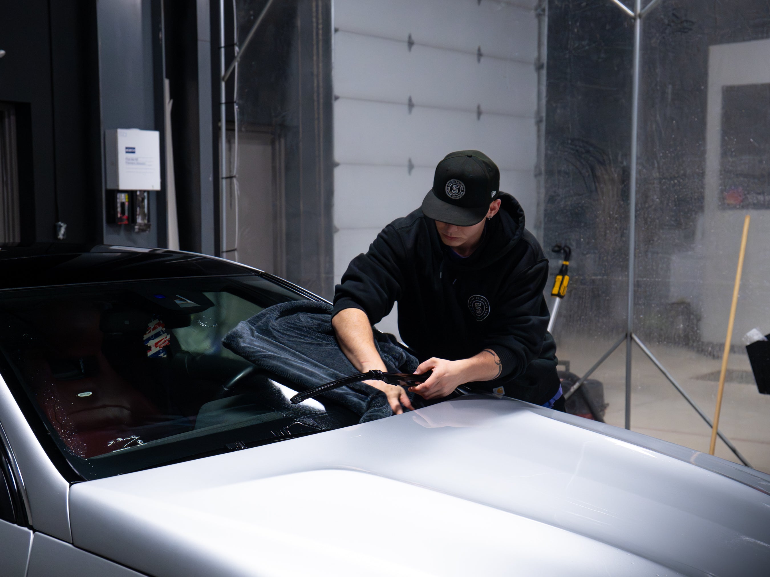 Professional drying a fully detailed car in a garage